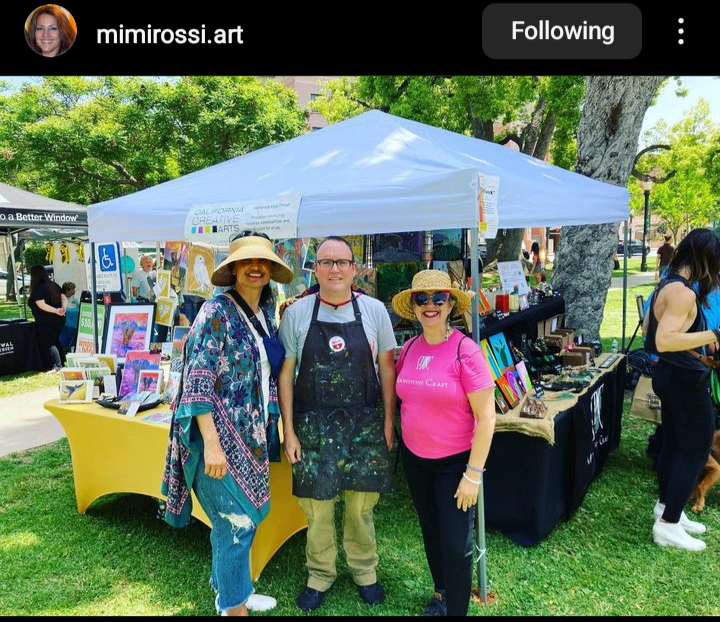 three artists in front of their booth at the art fair